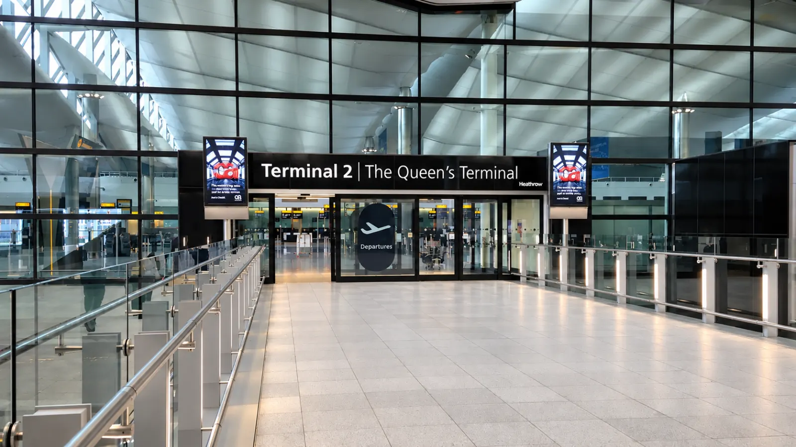 Heathrow terminal drop-off forecourt with a black private hire car