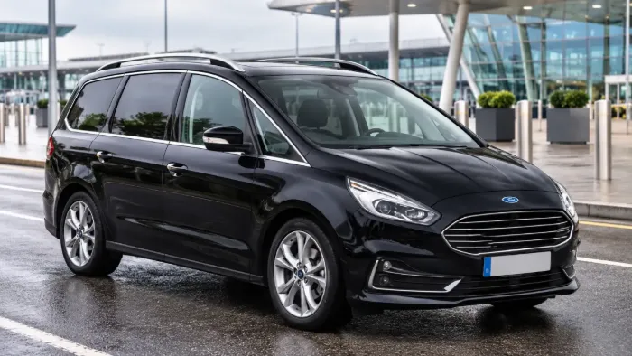 Black Ford Galaxy people carrier parked outside an airport terminal